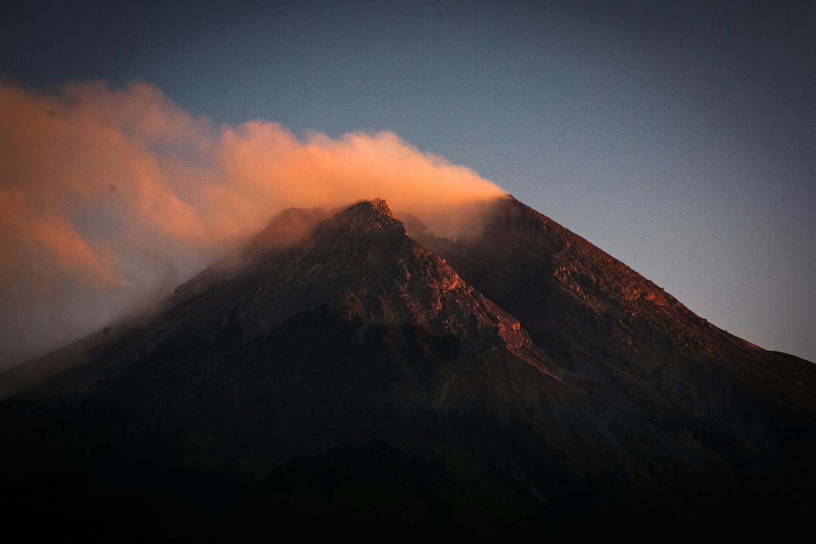 Breathtaking view of Mount Merapi with clouds during a vibrant sunset in Malang, Indonesia.