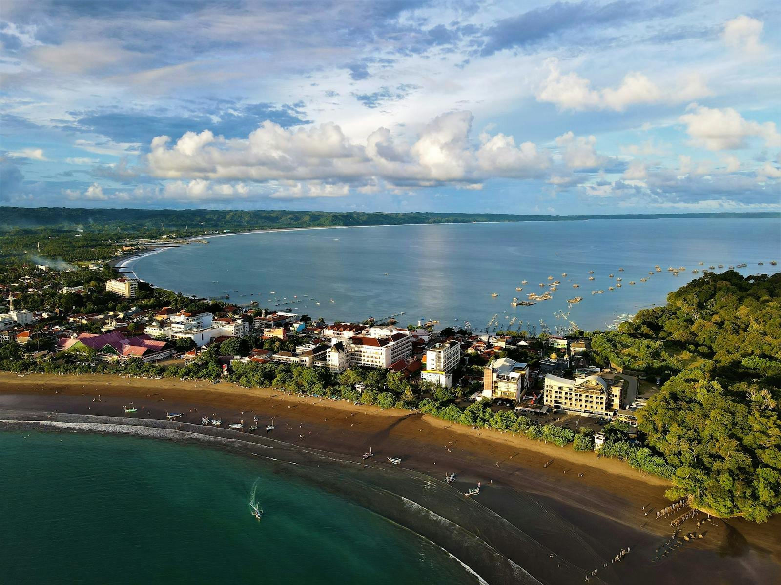 Explore the stunning aerial view of Pangandaran Beach and coastal town in Indonesia, showcasing its natural beauty.